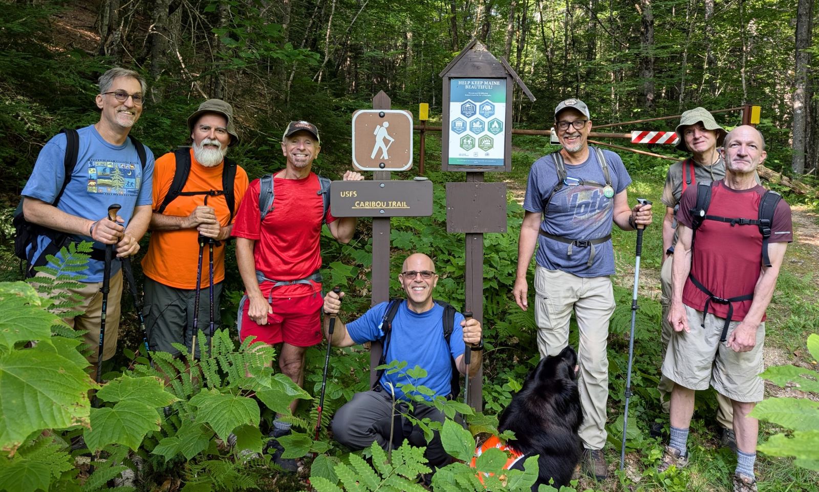 GayOutdoors members and a dog gathered at the Caribou Trail trailhead sign