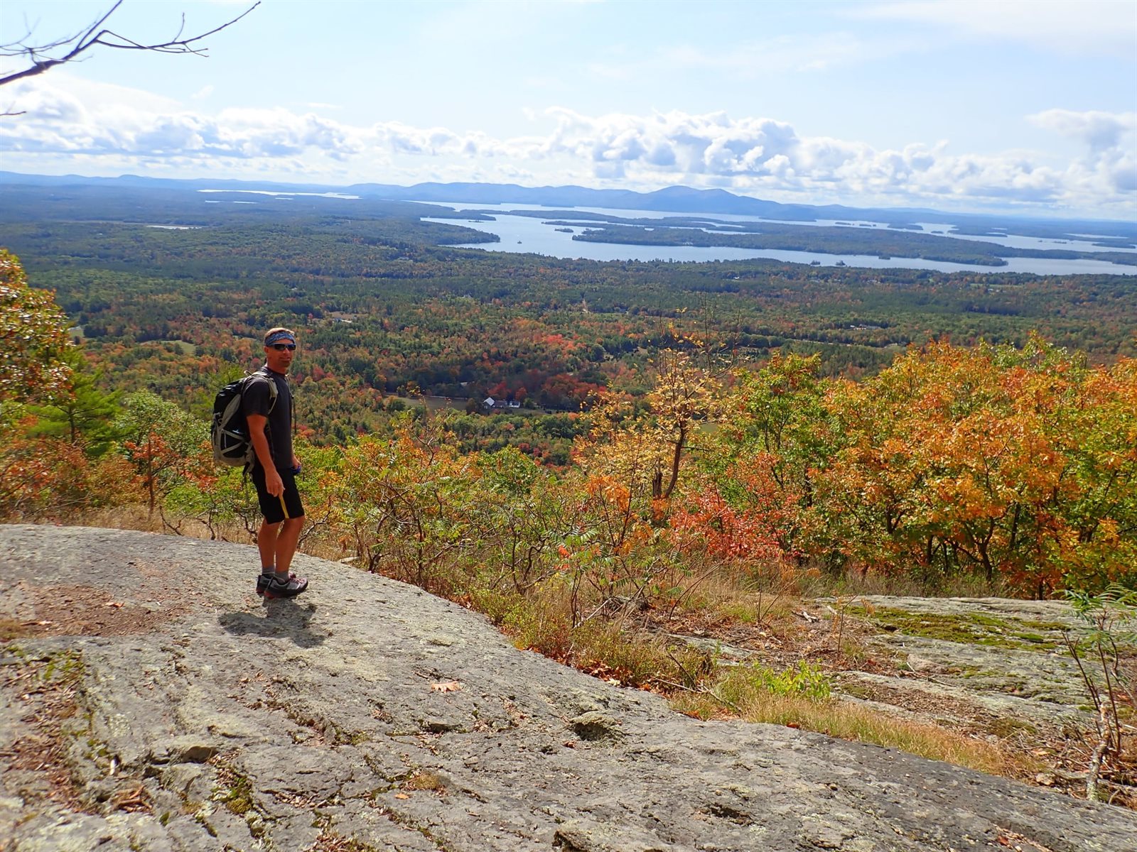 A hiker overlooking a lake framed by brilliant fall foliage